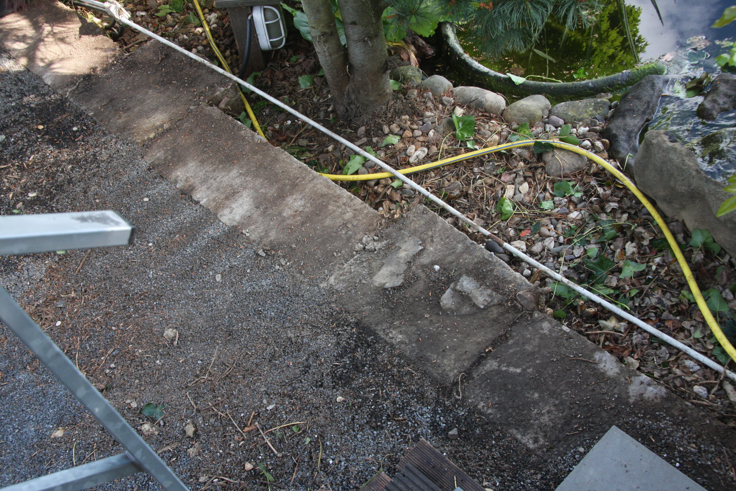 So sieht der vom Efeu befreite Rand der oberen Terrasse aus: Auf dieser Mauer stand früher mal der Pferdestall. Die Reste der Efeuwurzeln werden doch hoffentlich noch rausgehen. Vorne rechts liegt übrigens das Muster einer Grauwackeplatte, die uns Dennis mitgebracht hatte. Den Kies wird Rita in Kleinarbeit auflesen und...